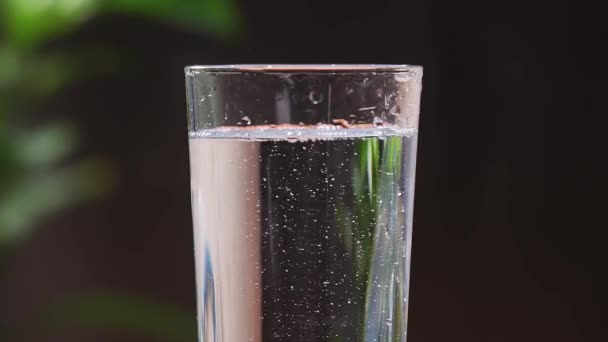 きれいな飲料水とガラス ガラスコップがテーブルの上にあり 男は水を注ぐ スローモーション4K — ストック動画
