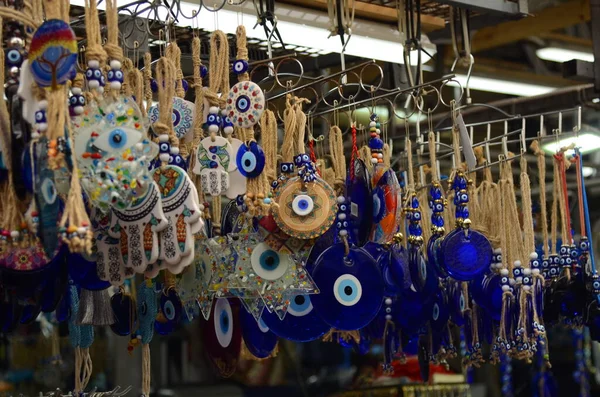 stock image Nazar in market. Blue and red Fatima eye close-up protective amulet against evil eye. Israeli and turkish souvenir. decorative glass blue souvenirs in the form of an eye