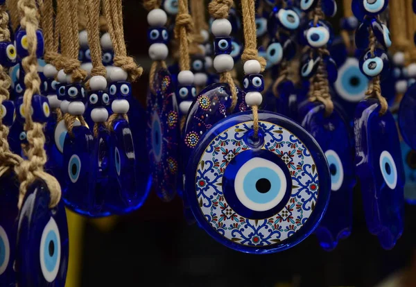 stock image Nazar in market. Blue and red Fatima eye close-up protective amulet against evil eye. Israeli and turkish souvenir. decorative glass blue souvenirs in the form of an eye