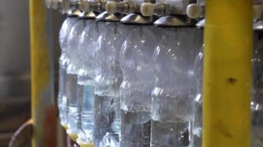 Plastik şişelerde maden suyu üretimi. Dolum ünitesinde 1,5 litre su bulunan plastik şişeye yakın çekim..