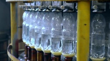 Plastik şişelerde maden suyu üretimi. Dolum ünitesinde 1,5 litre su bulunan plastik şişeye yakın çekim..