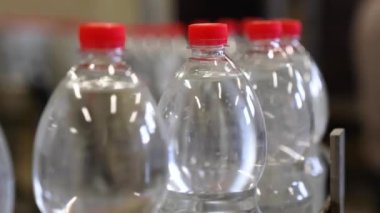 Plastik şişelerde maden suyu üretimi. Dolum ünitesinde 1,5 litre su bulunan plastik şişeye yakın çekim..
