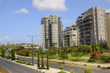 İsrail. Rishon Le Zion 18 Haziran 2023. Çiçekli sokaklar, modern yerleşim alanları. Sokakta ateş ağacı. Gayrimenkul yatırımları
