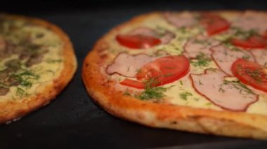 Sosisli, tavuklu ve mantarlı pizza iştah açıcı. Yakın plan, eller bir dilim pizza alır, pizza keser..
