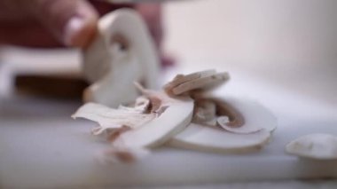 Şef şampiyon mantarlarını keser. Yakın plan bıçak ve şampiyonlar..