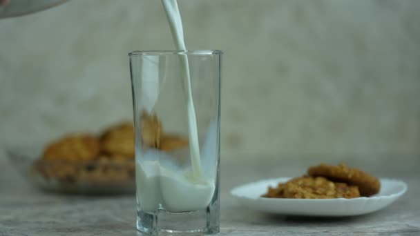 ミルクは オートミールクッキーとガラス 朝の朝食ミルクに注がれます スローモーション — ストック動画