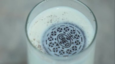 Kurabiyeli süt. Çikolata parçalı kurabiyeler sütün içinde yüzer. Sütlü Oreo. Klasik kombinasyon. Arka planda ünlü mavi ambalaj var. Ukrayna Kyiv 2 Mayıs 2023