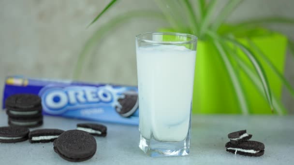 Blå Förpackning Oreo Cookies Bakgrunden Ett Glas Mjölk Med Chokladkakor — Stockvideo
