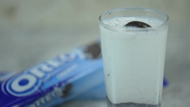 クッキーとミルク チョコレートチップクッキーは牛乳に浮かぶ 牛乳でオレオ 古典的な組み合わせ 有名な青いパッケージが背景にあります ウクライナキエフ2023年5月2日 — ストック動画