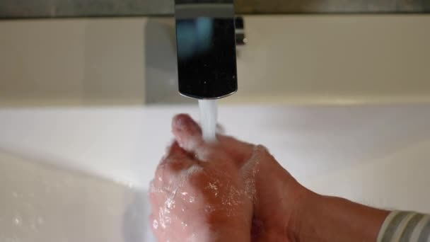 スローモーション タップから純粋な水の流れの下で人間の手の閉鎖 バスルームのモダンな蛇口 男は水を流して手を洗う クローズアップ — ストック動画