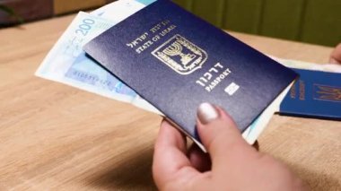 Bir İsrail vatandaşının pasaportu ve bir Ukrayna vatandaşının pasaportu, ülkene dönüş, aliyah. Kağıt para, yeni İsrail şekeli ve Hryvnia. Emme sepeti. Dönüş Yasası 'na göre yardım.