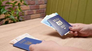 Bir İsrail vatandaşının pasaportu ve bir Ukrayna vatandaşının pasaportu, ülkene dönüş, aliyah. Kağıt para, yeni İsrail şekeli ve Hryvnia. Emme sepeti. Dönüş Yasası 'na göre yardım.