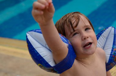 Kavram: Yaz tatili, tatil köyü. Tropik bir gezi. Havuzda yüzmeyi öğrenen tatlı bir çocuk. Sıçramalar, duygular, mayo. Tatil köyünde aile tatili, gezide çocuklar. Yaz tatili, otelin havuzunun yakınındaki bir dinlenme odasında dinleniyor..