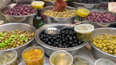 Salamura edilmiş zeytinlerin iştah açıcı çeşitleri. Tel Aviv 'de bir markette yeşil ve siyah zeytin. Büyük, güzel zeytin turşusu..