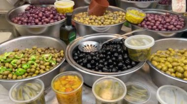 Salamura edilmiş zeytinlerin iştah açıcı çeşitleri. Tel Aviv 'de bir markette yeşil ve siyah zeytin. Büyük, güzel zeytin turşusu..