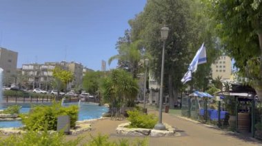  Güzel bir parkta çeşme, rüzgarda İsrail bayrağı. Yavaş çekim