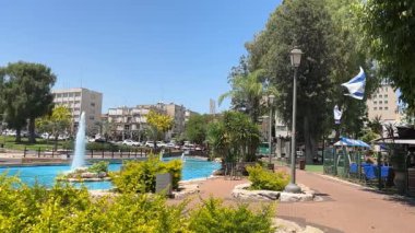  Güzel bir parkta çeşme, rüzgarda İsrail bayrağı. Yavaş çekim