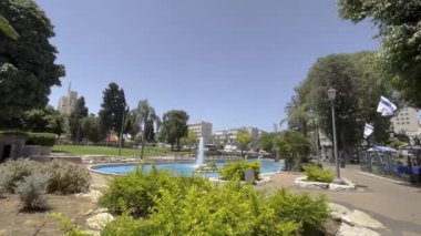 Güzel bir parkta çeşme, rüzgarda İsrail bayrağı. Yavaş çekim