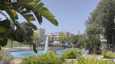  Güzel bir parkta çeşme, rüzgarda İsrail bayrağı. Yavaş çekim