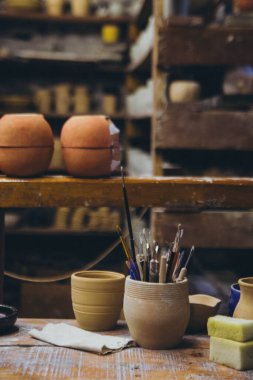 brushes on the table among the jugs clipart