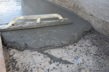 Beton dökme kavramları. Kelepçelerle örgü güçlendirmek için beton tozu. Yeni dökülmüş beton. Yeni dökülmüş beton kaldırım kare maleye