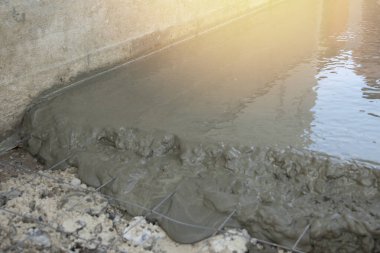 Metal ağla güçlendirilmek için yeni dökülmüş beton. Yakın plan.