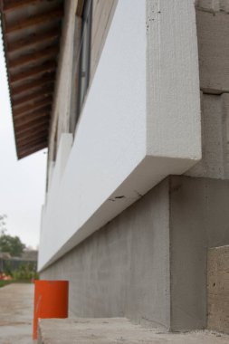 Sert stiroköpük yalıtım kağıdıyla tuğla ev duvarının yakın plan detayları..
