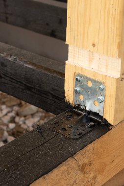 Terasın ahşap çerçevesine bituminöz astar takıyorum. Ahşap parmaklıklar ve tahtalar su geçirmez. Su geçirmez tahta. Bağlamak için metal köşe.