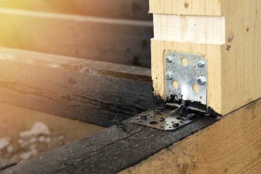 Applying a bituminous primer to the wooden frame of the terrace. Waterproofing of wooden bars and boards. Waterproof wood. The metal corner for fastening. clipart