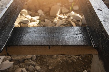 Terasın ahşap çerçevesine bituminöz astar takıyorum. Ahşap parmaklıklar ve tahtalar su geçirmez. Su geçirmez tahta.