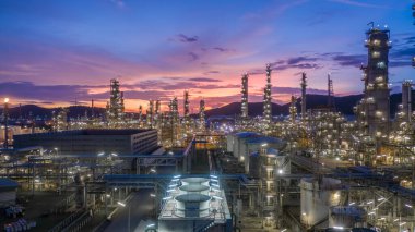 Geceleri petrol rafinerisi arka planına sahip hava manzaralı petrol ve gaz tankı, gece petrokimya fabrikasının parıltılı ışıklandırması, petrol üretimi, petrokimya fabrikasında ürün tankı.