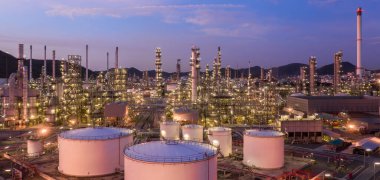Geceleri petrol rafinerisi arka planına sahip hava manzaralı petrol ve gaz tankı, gece petrokimya fabrikasının parıltılı ışıklandırması, petrol üretimi, petrokimya fabrikasında ürün tankı.