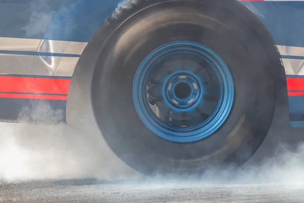 Close up car wheel with smoke on the asphalt road speed track, Car wheel drifting and smoking on track, Car wheel spinning.