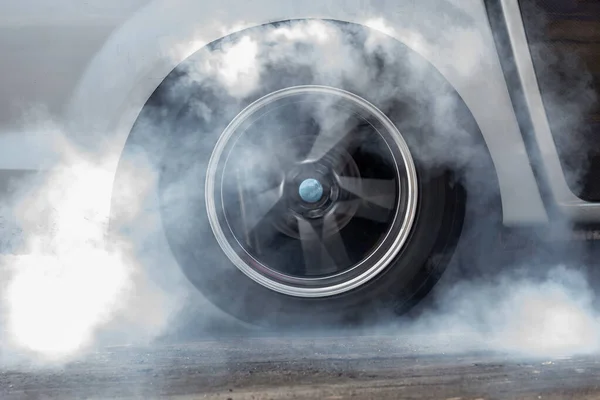 アスファルトロードスピードトラックの煙で車輪を閉じ 車輪が漂ってトラックで喫煙 車輪の回転 — ストック写真