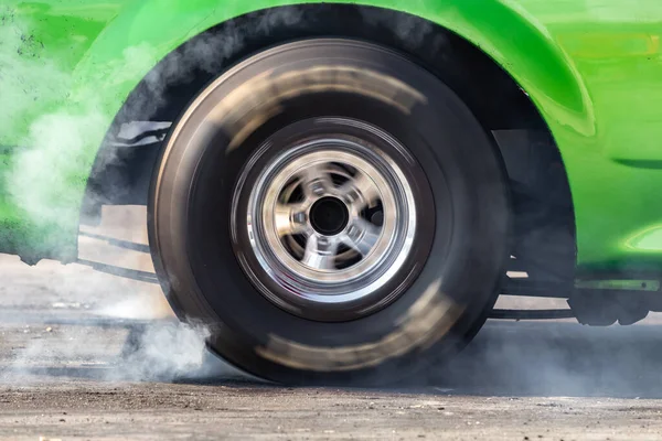 Close up car wheel with smoke on the asphalt road speed track, Car wheel drifting and smoking on track, Car wheel spinning.