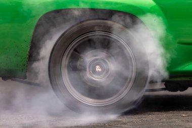 Sürüklenen araba yanan lastik, yarışmadan önce lastikleri ısıt. Sürüklenen araba tekerleği, dönen tekerlek ve duman. Sürüklenen yarış arabası lastik lastiklerini yakıyor..