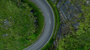 Dağ yolundaki yeşil ormandan geçen hava manzaralı yol yeşil ormandan geçen asfalt yolda giden araba yukarıdan geçen kıvrımlı yol..