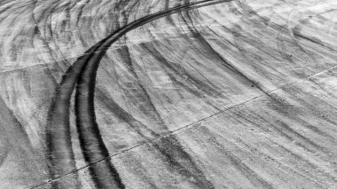 Asfalt pistinde lastik izi asfalt yarış pisti dokusu ve arka planda soyut siyah lastik izleri yarış pistinde asfalt yolda kayma izi asfalt yolda lastik izi.