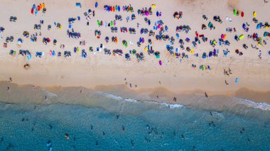 Hava manzaralı insanlar kumlu sahil ve mavi deniz suyunda tatil, Sandy plajı renkli şemsiyeli turistler yüzüyor, tropikal deniz manzaralı turkuaz su seyahati ve tatil.