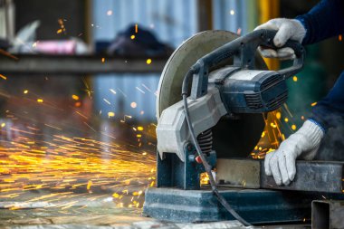 Elektrikli öğütücüyle metal işleme, metal işçiliğinde kıvılcımlar, fabrikadaki çelik yapıda elektrik tekerleği öğütme. Öğütücü tekerlekten kıvılcımlar, endüstriyel atölyedeki elektrikli öğütücü.