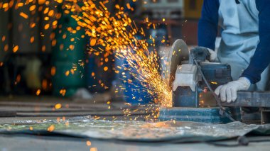 Elektrikli öğütücüyle metal işleme, metal işçiliğinde kıvılcımlar, fabrikadaki çelik yapıda elektrik tekerleği öğütme. Öğütücü tekerlekten kıvılcımlar, endüstriyel atölyedeki elektrikli öğütücü.