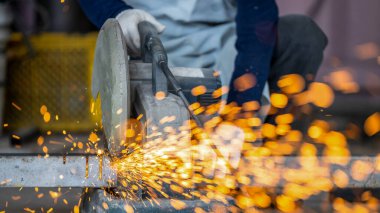 Elektrikli öğütücüyle metal işleme, metal işçiliğinde kıvılcımlar, fabrikadaki çelik yapıda elektrik tekerleği öğütme. Öğütücü tekerlekten kıvılcımlar, endüstriyel atölyedeki elektrikli öğütücü.