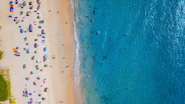 Hava manzaralı insanlar kumlu sahil ve mavi deniz suyunda tatil, Sandy plajı renkli şemsiyeli turistler yüzüyor, tropikal deniz manzaralı turkuaz su seyahati ve tatil.