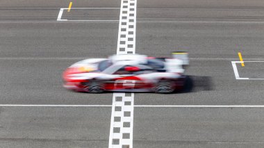 Hareket bulanıklığı çeken yarış arabası hız yolunda, uluslararası pistte yarış pisti geçişi başlangıç ve bitiş çizgisinde yarış arabası başlangıç ve bitiş çizgisinde, yarış arabası başlangıç ve bitiş çizgisinde,.