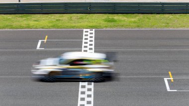 Hareket bulanıklığı çeken yarış arabası hız yolunda, uluslararası pistte yarış pisti geçişi başlangıç ve bitiş çizgisinde yarış arabası başlangıç ve bitiş çizgisinde, yarış arabası başlangıç ve bitiş çizgisinde,.
