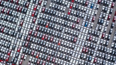 Aerial view new car lined up in the port for dealership business import and export, New car lined up parking lot outside an automobile automotive factory distribution for sale. clipart