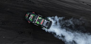 Araba asfalt yarış pistinde, yanan tekerlek lastiklerinden çıkan dumanla sürükleniyor, Sürüklenen motorspor araba drift yarışı, asfalt yarış pistindeki profesyonel sürüş arabası, araba hareketi bulanık motor sporu..