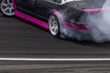 Hareket bulanıklığı yarış arabasının tekerlek lastiği patlak lastik, beyaz duman yarış arabasının tekerlek kaymasından çıkan duman yol yüzeyinde yanan lastikler, hız yolunda motorsporunun tekerleği yanmış lastikler..
