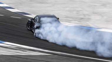 Motorsport araba asfalt yarış pistinde çok dumanlı bir şekilde sürükleniyor.