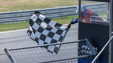 Bitiş podyumunda damalı bayrak sallayan, bitiş çizgisinde ve kareli bayrak sallayan yarış pistinde yarış bayrağı, zafer başarısı motorsporu.